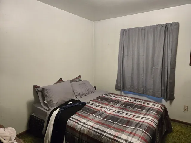 a bed sitting in a bedroom next to a wooden cabinet