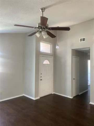 a view of a room with wooden floor and a ceiling fan