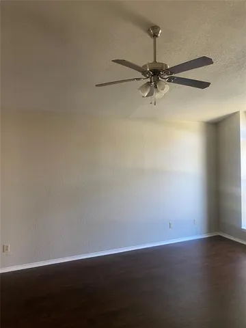 an empty room with a potted plant and a ceiling fan