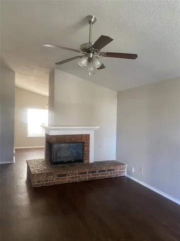 a living room with a fireplace and a ceiling fan