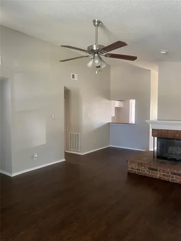 an empty room with wooden floor a ceiling fan and a window