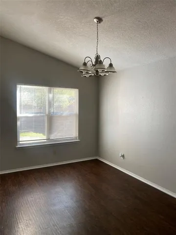 an empty room with wooden floor windows and glass door