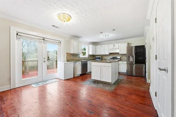 a kitchen with stainless steel appliances a refrigerator sink and cabinets