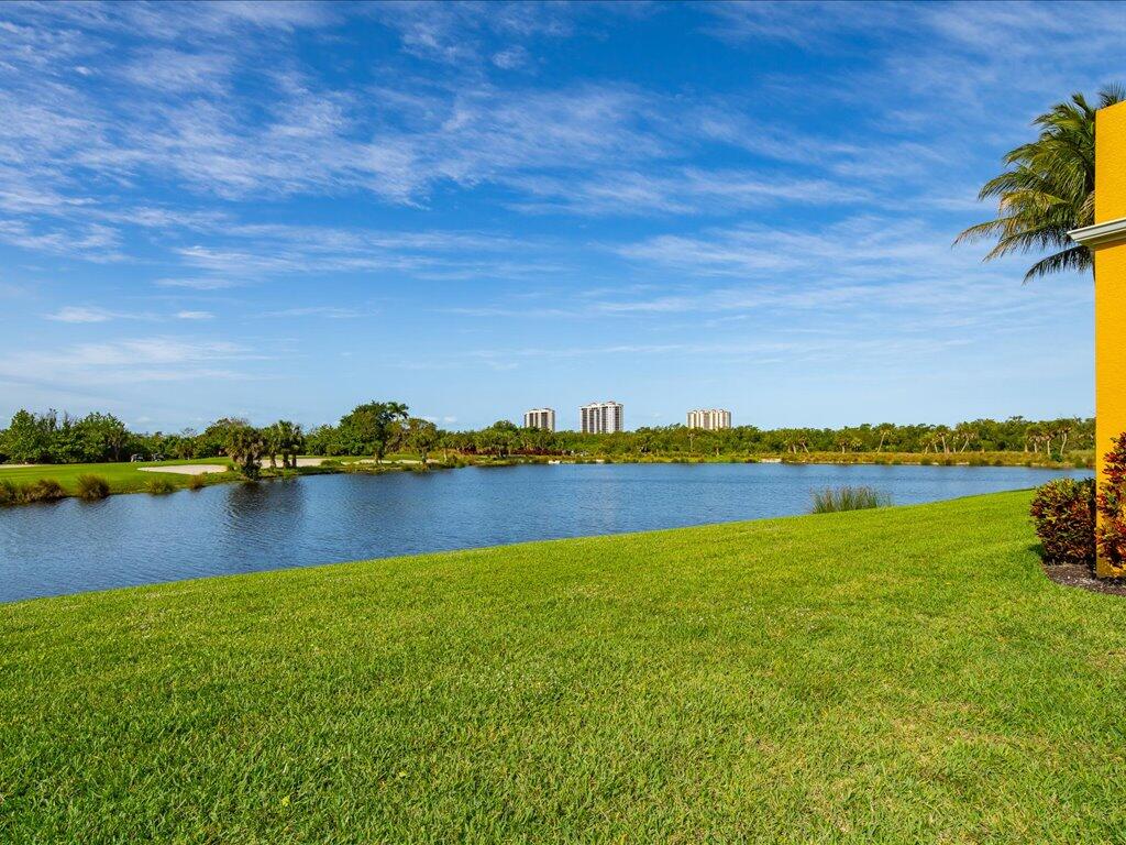 1498 Borghese Lane, Unit 101 Naples, FL 34114 - Photo 12 of 31 a view of a lake with houses in the back