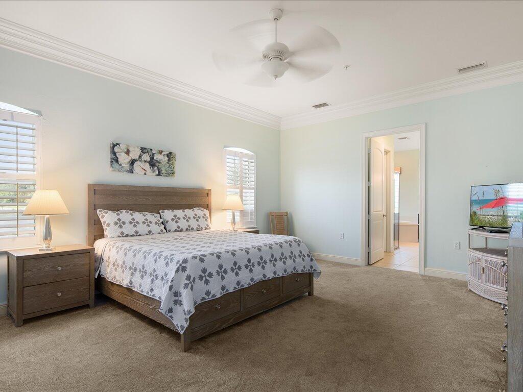 1498 Borghese Lane, Unit 101 Naples, FL 34114 - Photo 15 of 31 a bedroom with a bed and a flat screen tv