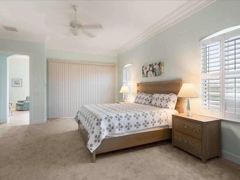 1498 Borghese Lane, Unit 101 Naples, FL 34114 - Photo 16 of 31 a bedroom with a bed and a window