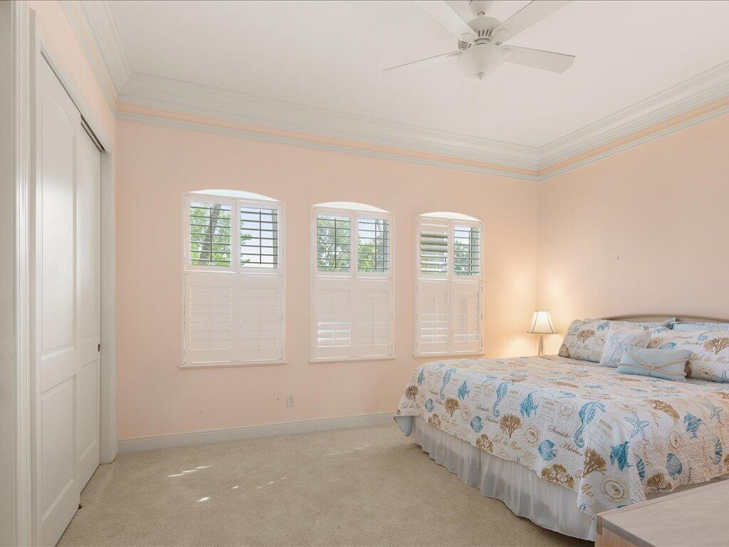 1498 Borghese Lane, Unit 101 Naples, FL 34114 - Photo 19 of 31 a bedroom with a bed and a window