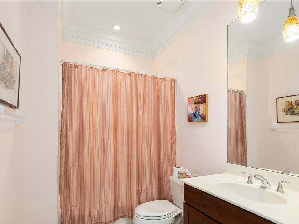 1498 Borghese Lane, Unit 101 Naples, FL 34114 - Photo 23 of 31 a bathroom with a sink a toilet and shower curtain