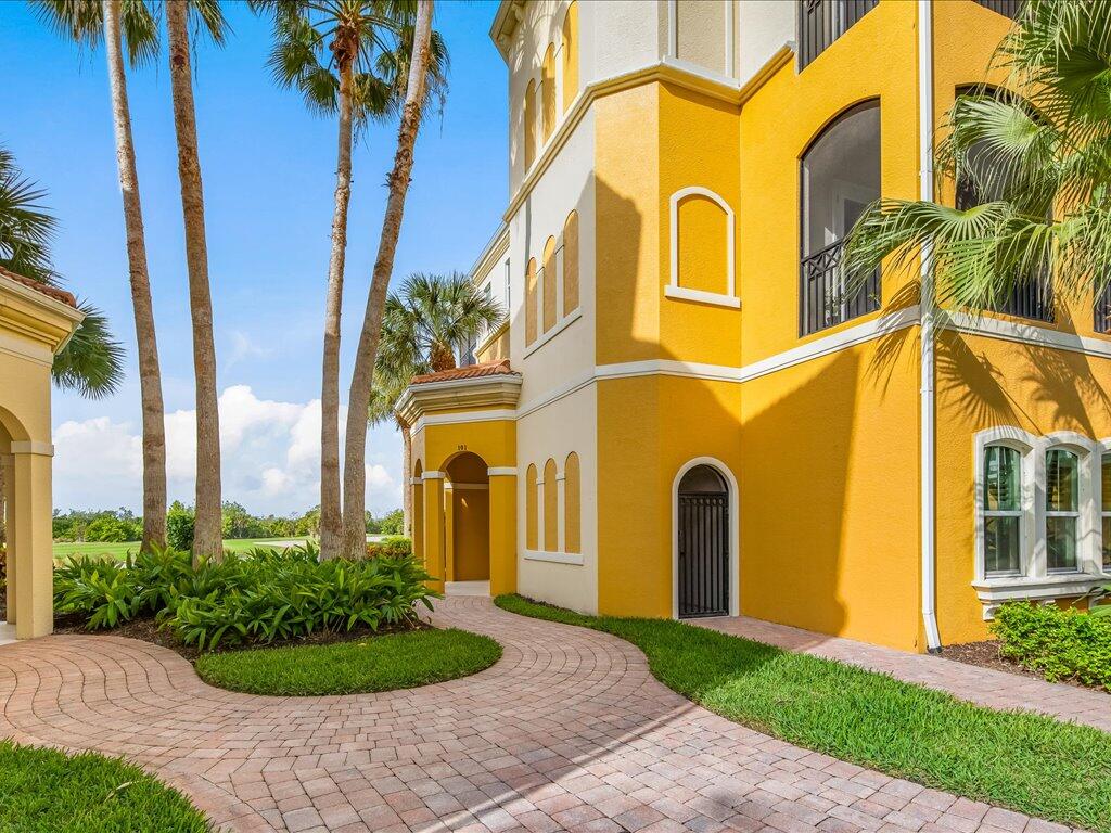 1498 Borghese Lane, Unit 101 Naples, FL 34114 - Photo 26 of 31 a front view of a house with a garden