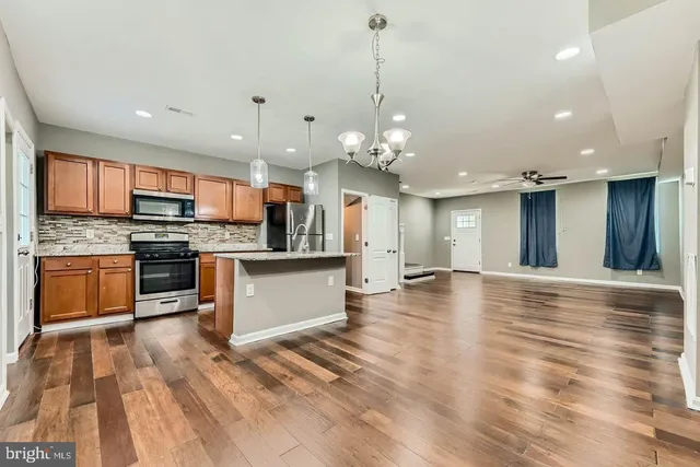 a large kitchen with kitchen island a sink stainless steel appliances and cabinets