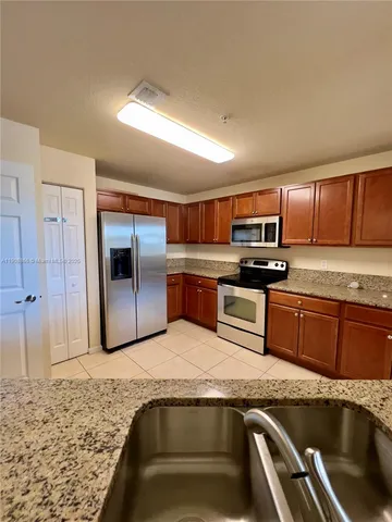 a kitchen with granite countertop stainless steel appliances and wooden cabinets