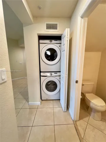 a bathroom with a toilet and a washing machine in a utility room