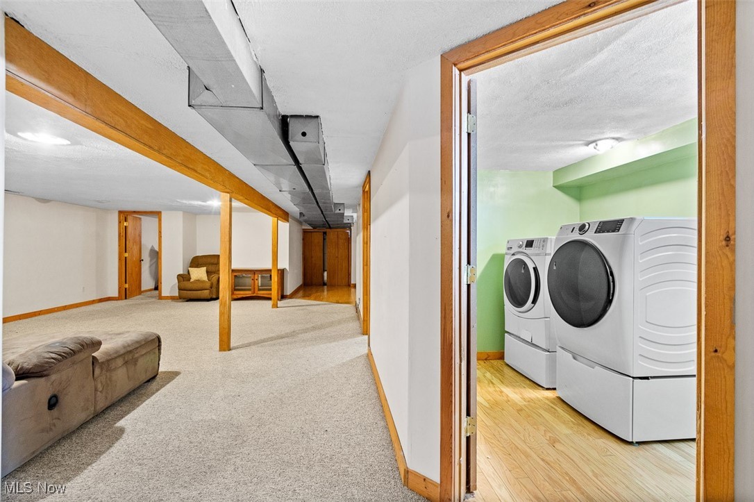 5208 Canaan Center Road Wooster, OH 44691 - Photo 22 of 33 Clothes washing area with washer and clothes dryer, a textured ceiling, wood finished floors, carpet flooring, and baseboards