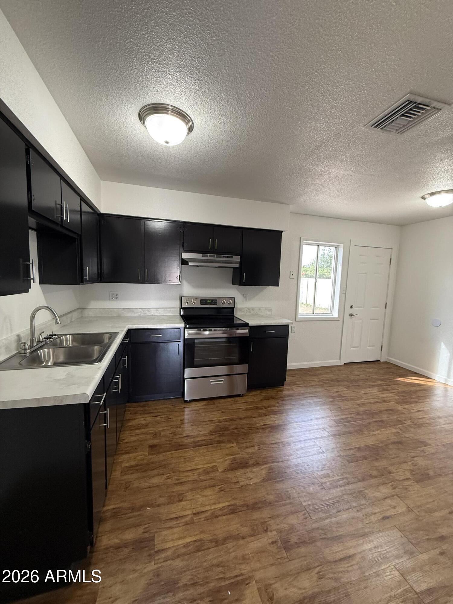 5807 West Flower Street Phoenix, AZ 85031 - Photo 4 of 11 a kitchen with granite countertop a sink counter top space appliances and cabinets
