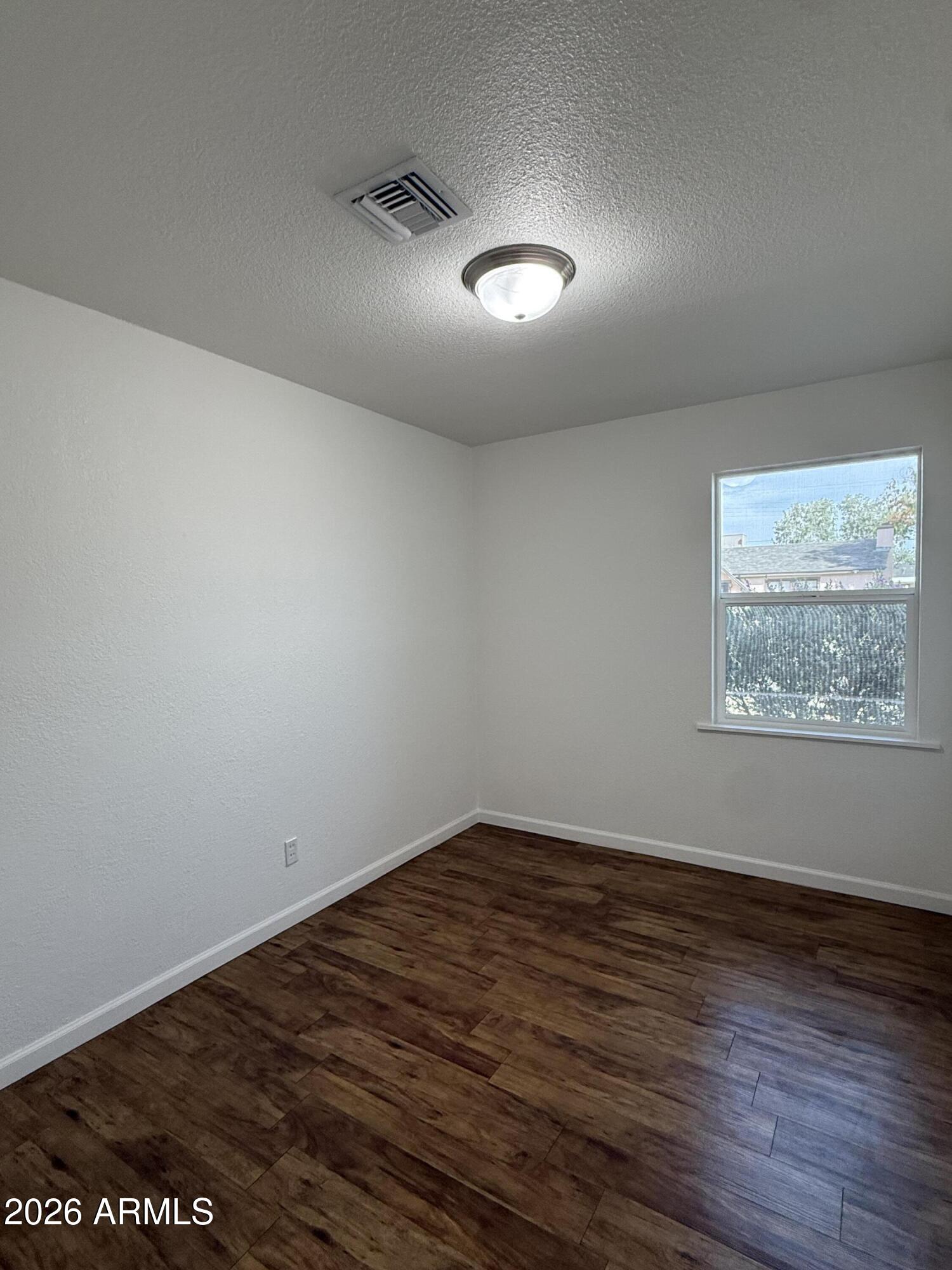 5807 West Flower Street Phoenix, AZ 85031 - Photo 6 of 11 an empty room with wooden floor and windows