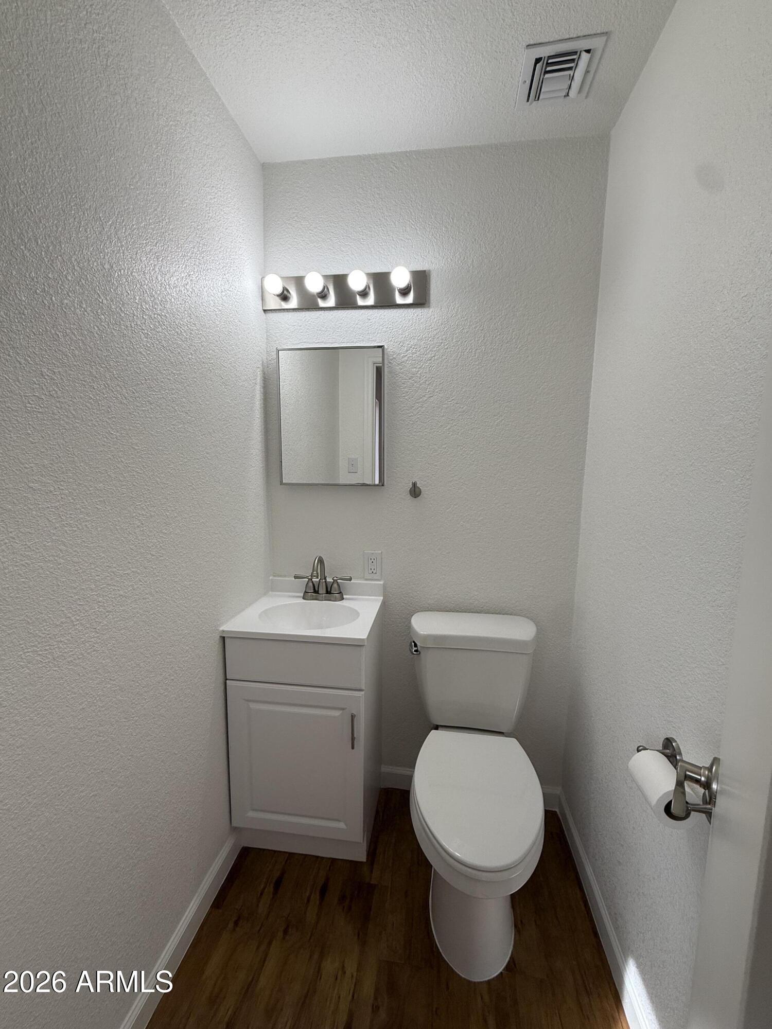 5807 West Flower Street Phoenix, AZ 85031 - Photo 10 of 11 a bathroom with a toilet a sink and mirror