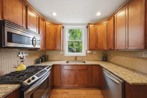a kitchen with stainless steel appliances granite countertop a stove sink and cabinets
