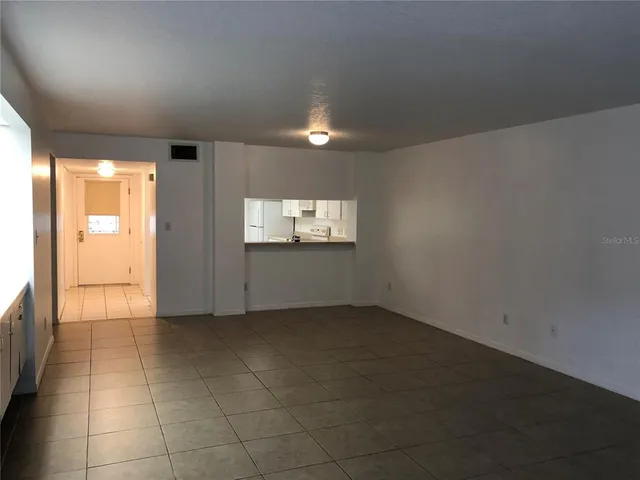 an empty room with windows and fireplace