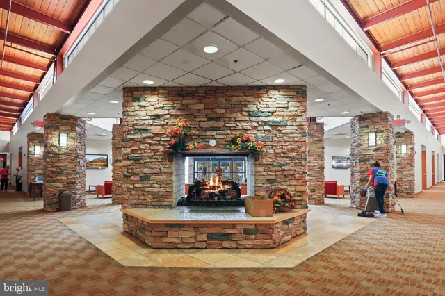 a living room with fireplace furniture and a large window