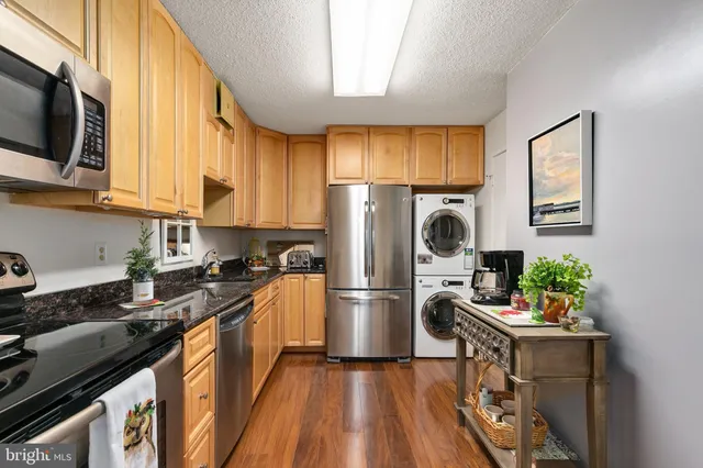 a kitchen with a refrigerator a stove top oven a sink dishwasher and wooden cabinets