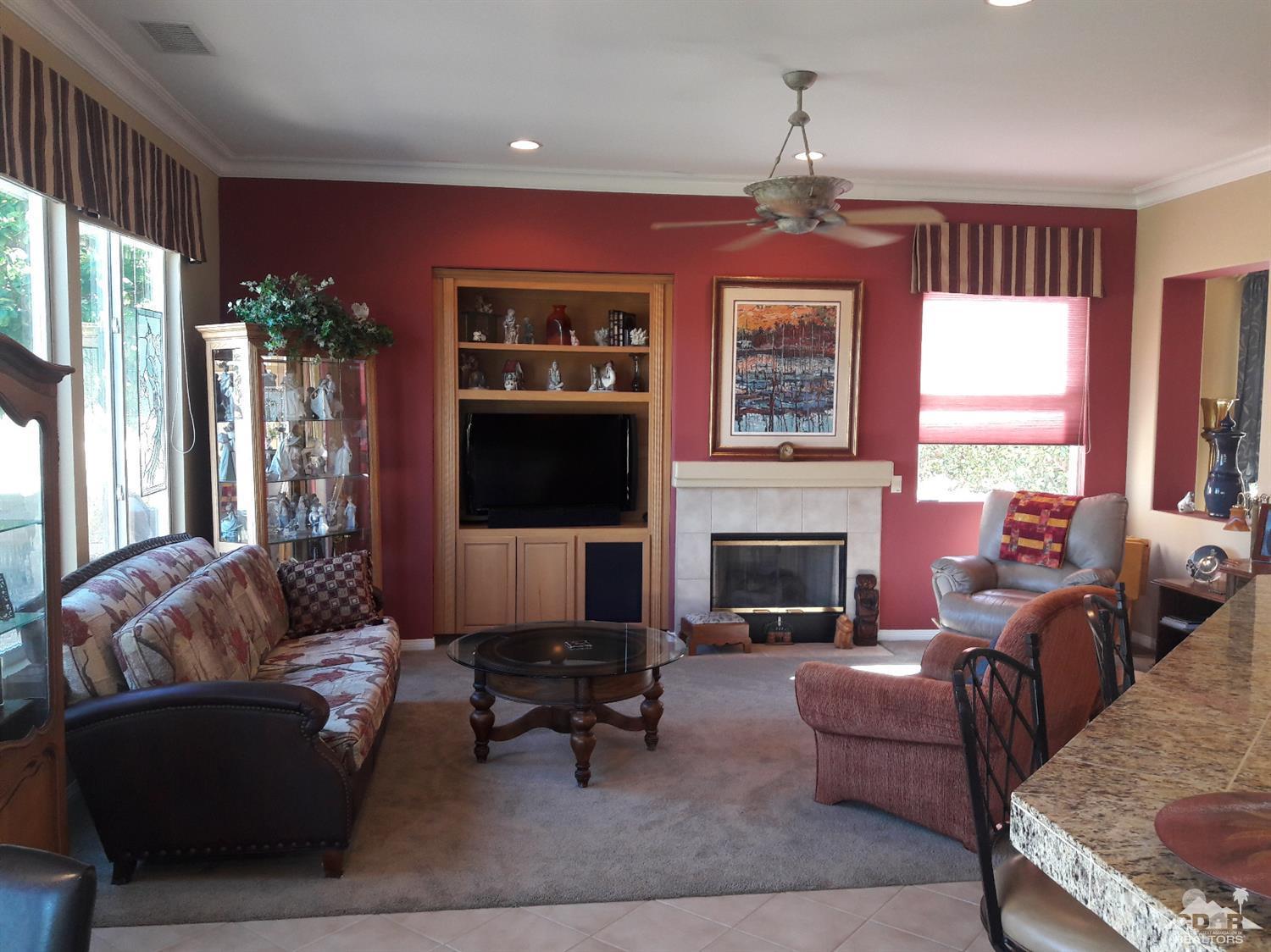 80546 Knightswood Road Indio, CA 92201 - Photo 3 of 35 a living room with furniture a fireplace and a flat screen tv