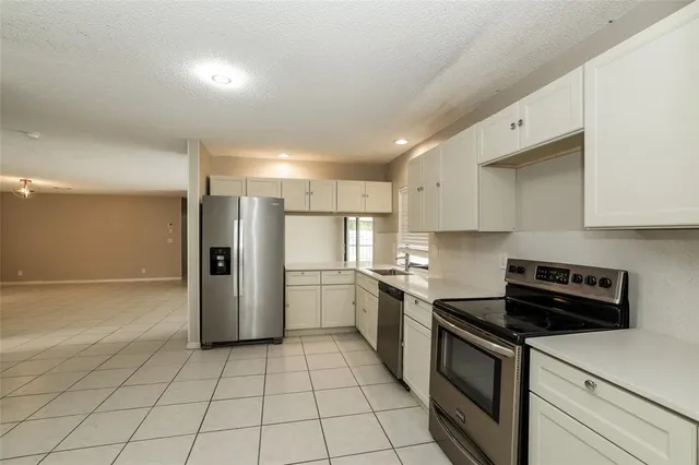 a kitchen with a sink a refrigerator and cabinets