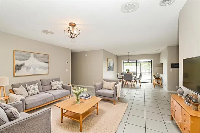 a living room with furniture a flat screen tv and a table