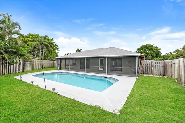 a view of an house with backyard and swimming pool
