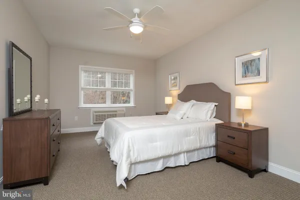 a bedroom with a bed dresser and a window