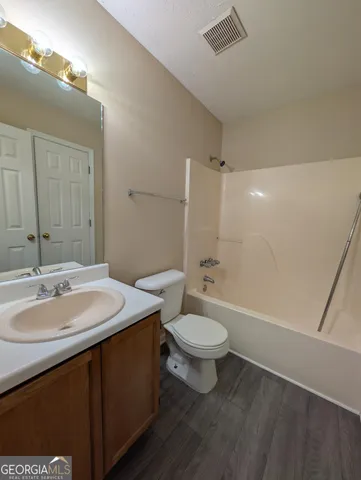 a bathroom with a sink a toilet a mirror and bathtub