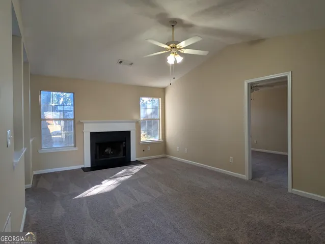 a view of empty room with fireplace and fan