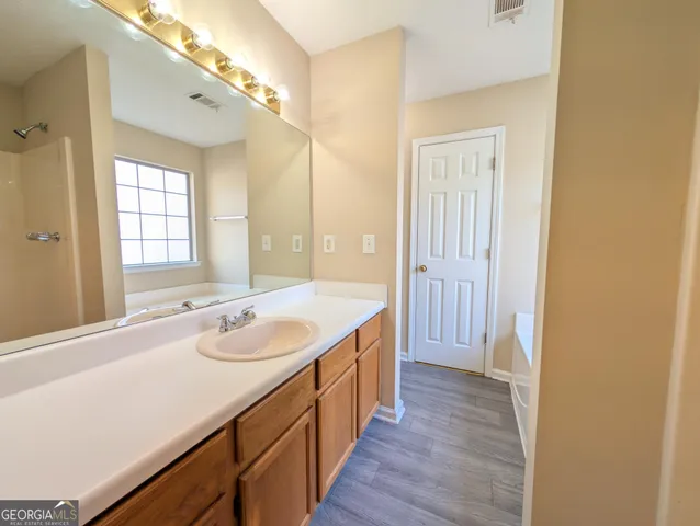 a bathroom with a sink a vanity and a large mirror