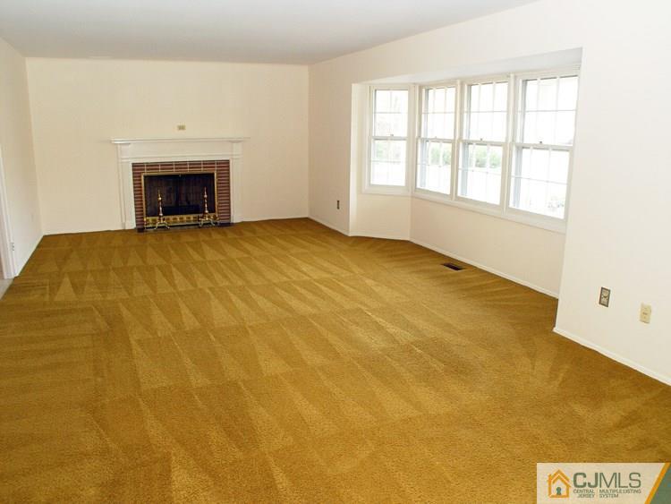 124 Drake Road Somerset, NJ 08873 - Photo 4 of 24 a view of an empty room with a fireplace and a window