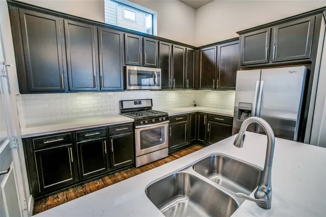 a kitchen with granite countertop a sink stove and refrigerator