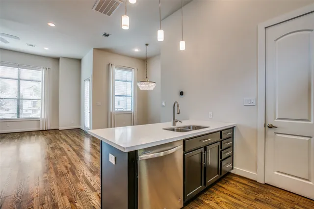 a kitchen with stainless steel appliances granite countertop a sink and dishwasher with wooden floor