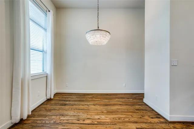a view of a room with wooden floor and white walls