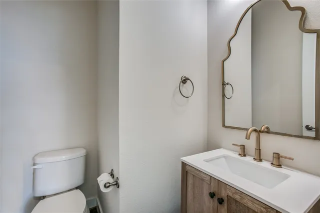a bathroom with a sink vanity mirror and toilet
