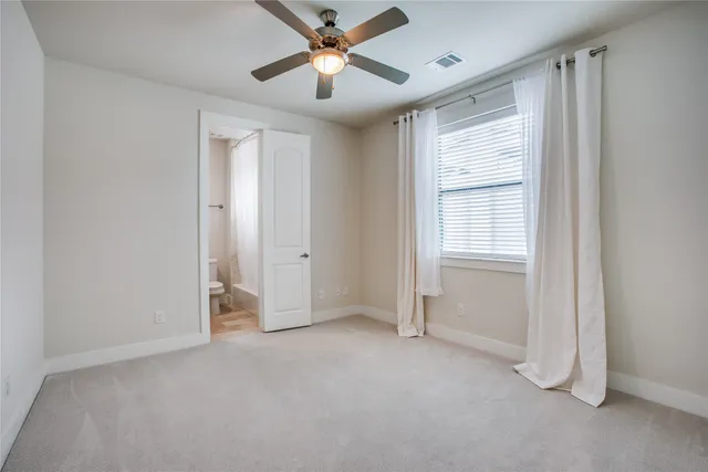 a view of an empty room with chandelier fan