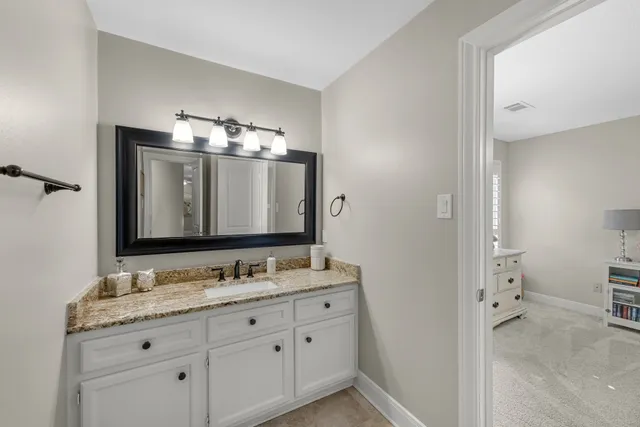 a bathroom with a granite countertop double vanity sink mirror and