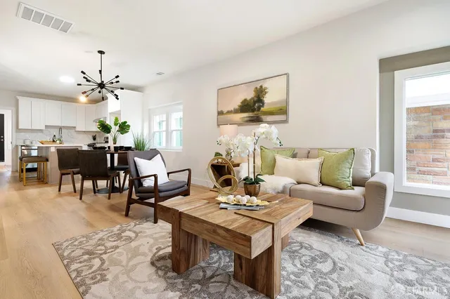 a living room with furniture a dining table and a window