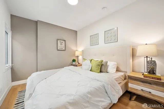 a bedroom with a bed and wooden floor