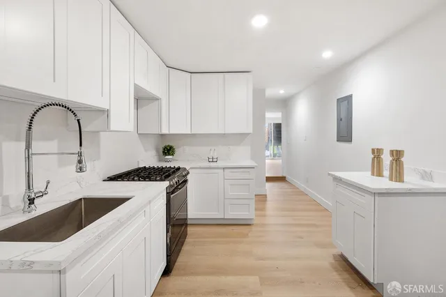 a kitchen with a stove and white cabinets