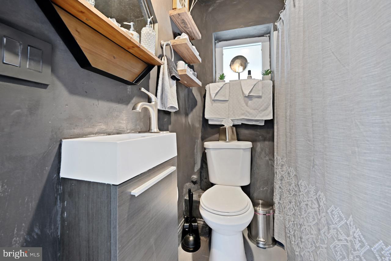 1709 Bank Street Baltimore, MD 21231 - Photo 40 of 49 a bathroom with a toilet a sink and a mirror