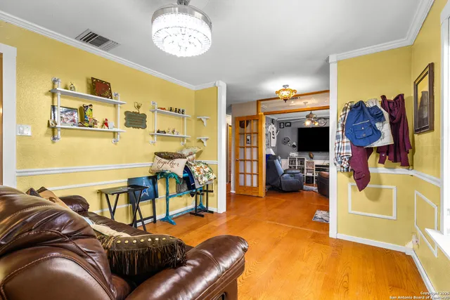 a living room with furniture a flat screen tv and a chandelier