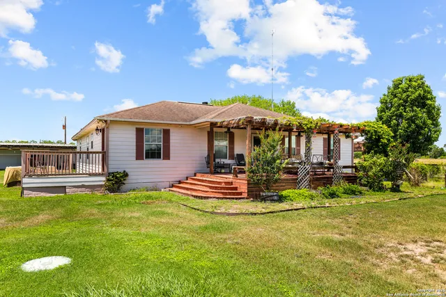 a view of a house with backyard and sitting area