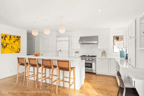 a kitchen with stainless steel appliances granite countertop a stove and white cabinets