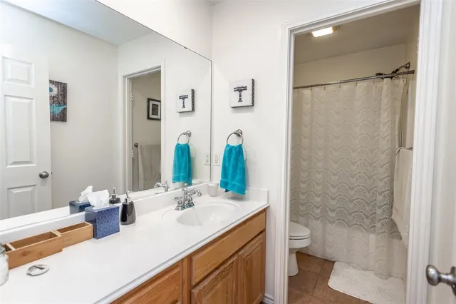 a bathroom with a sink toilet double vanity and shower