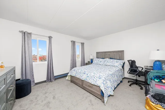 a spacious bedroom with a bed and a dresser in it