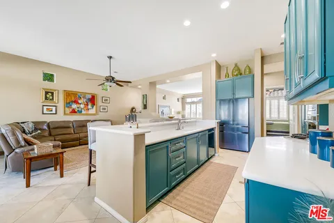 a kitchen with stainless steel appliances kitchen island granite countertop a sink and a refrigerator