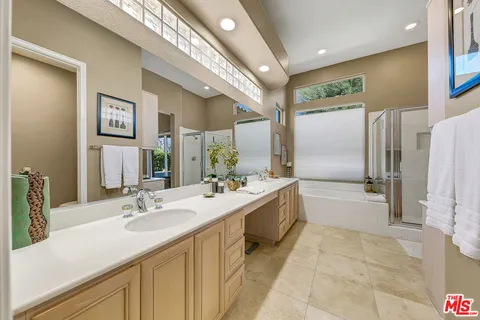 a bathroom with a tub sink and mirror